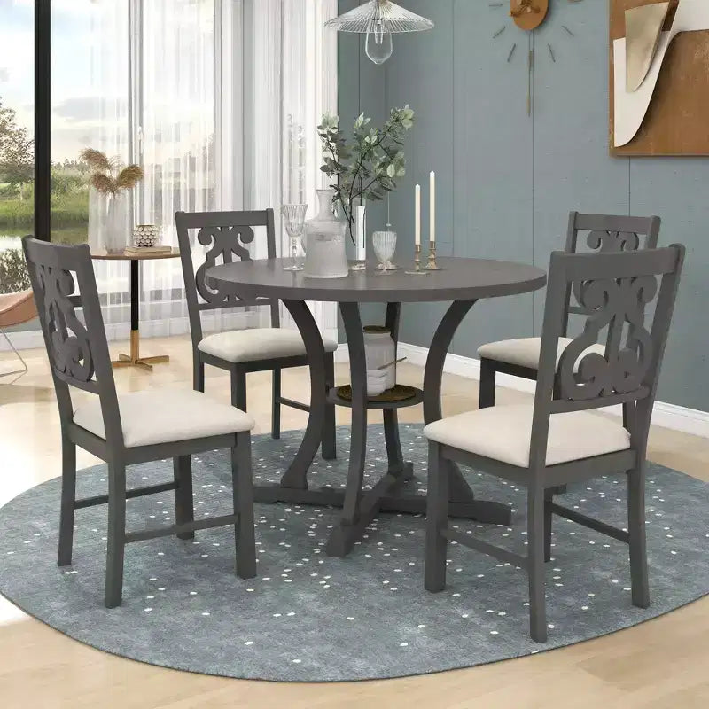 Set da pranzo da 5 pezzi con tavolo rotondo in legno e sedie con gambe dalla forma particolare e schienale traforato dal design raffinato per cucina
