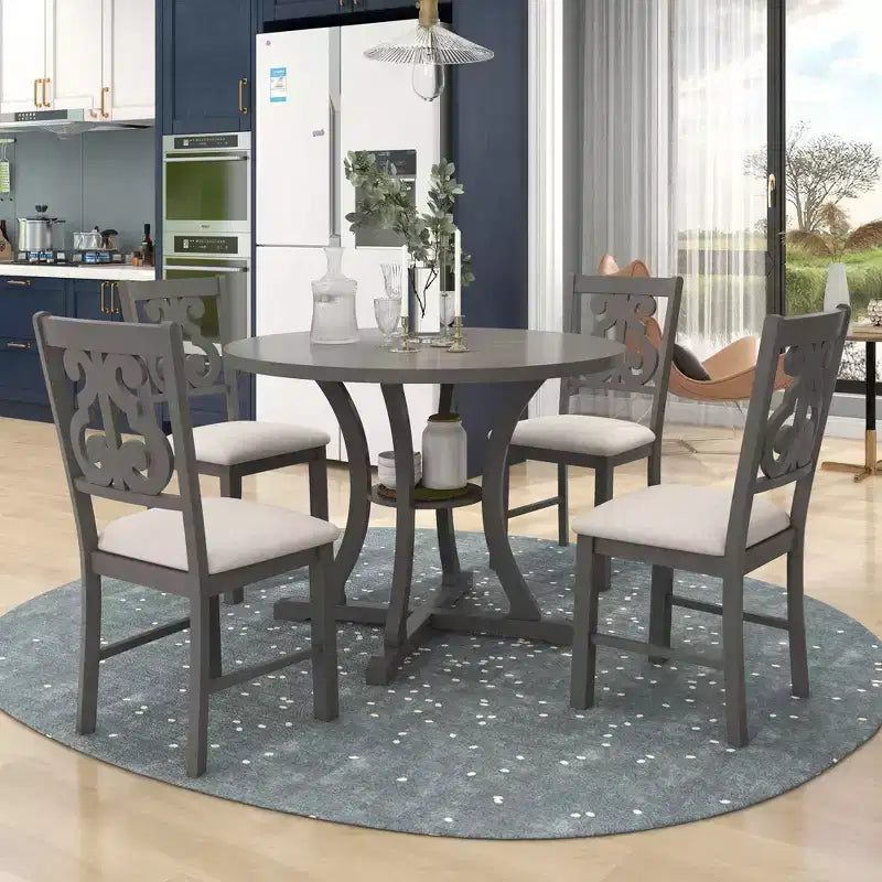 Set da pranzo da 5 pezzi con tavolo rotondo in legno e sedie con gambe dalla forma particolare e schienale traforato dal design raffinato per cucina